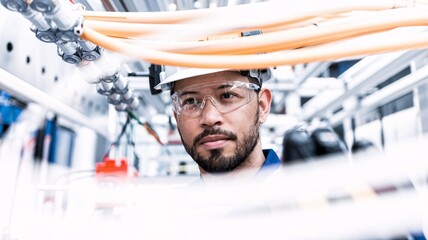 A close-up of an engineer working inside a fiber optic junction box, connecting cables to ensure high-speed internet service in a commercial building.