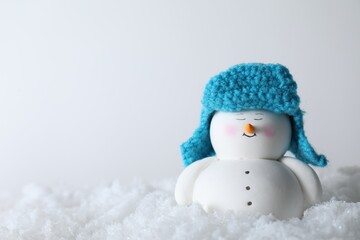 Poster - Cute decorative snowman on artificial snow against light background. Space for text