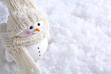 Poster - Cute decorative snowman on artificial snow, closeup. Space for text