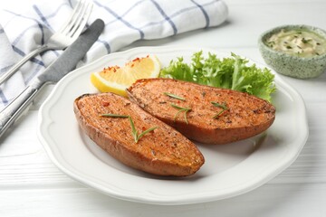 Tasty baked sweet potato served on white wooden table, closeup