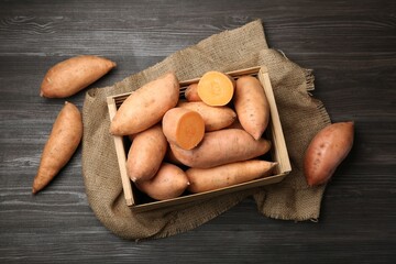 Sticker - Fresh raw sweet potatoes in crate on wooden table, top view