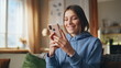 © stockbusters - Cheerful woman looking smartphone sitting home couch closeup. Happy lady mobile