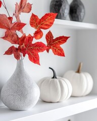 Canvas Print - Modern autumn home decor on a white shelf with pumpkins and geometric vase with red leaves