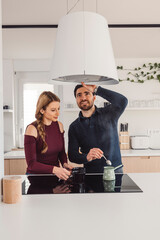 Wall Mural - The couple go about their daily chores in the apartment. The couple talks in the kitchen, sits on the sofa, at the dining table.