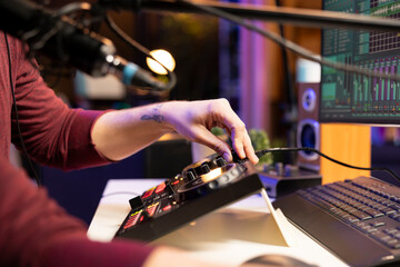 Aufkleber - Audio engineer twisting pre amp knobs to edit tunes in post production, working with stereo equipment and mixing console. Young musician recording new music in his home studio. Close up.