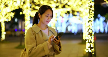 Wall Mural - Woman look at the mobile phone in city at night