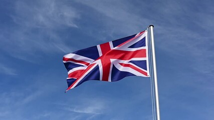 Wall Mural - Slow motion, flag of Great Britain, United Kingdom fluttering in the wind against a blue sky