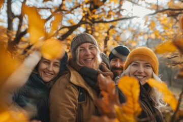 Wall Mural - Group of friends having fun in autumn park. They are smiling and looking at camera.