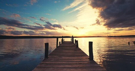 Wall Mural - colorful tropical sunset over wooden fishing pier and ripple sea water video