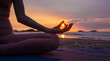 © APchanel - Silhouette of sport woman performing a yoga pose on the beach at sunset, with the sun setting behind the horizon and the calm sea .Yoga is meditation and healthy sport relaxing on summer holiday
