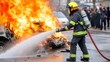 © Moopingz - A firefighter in full gear uses a hose to extinguish a car on fire, surrounded by intense flames and smoke.