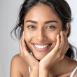 © Niks Ads - An attractive indian woman with radiant, glowing skin is smiling and showing her perfect face on a white background.