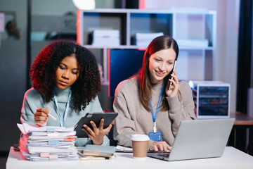 Two businesswoman discuss investment project working and planning strategy with tablet laptop computer