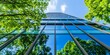 © Monirknn - Glass building with green trees and blue sky in the background, eco-friendly office space concept, generative ai
