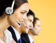 © vgstudio - Contact center servise concept image. Call centre phone operators, advisors; adviser answering workers working at workplace together. Isolated over orange yellow background. Representative.