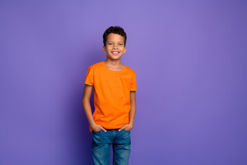 Sticker - Portrait of nice little schoolchild posing empty space wear orange t-shirt isolated on purple color background