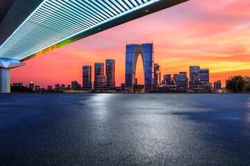 Asphalt road square and bridge with modern city buildings scenery at night in Suzhou, China. car advertising background.