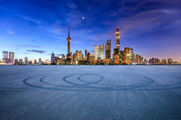 Asphalt road square and modern city buildings scenery at night in Shanghai. car advertising background.