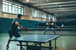 © Ariestia - Two Men Playing Table Tennis in an Indoor Facility