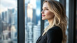 © Ruslan - A successful influential businesswoman boss in her office stands near the panoramic windows and looks into the distance dreaming of future victories and achievements