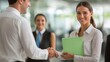 © Liliia - A woman shakes hands with a man in a business setting