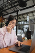 © Ton Photographer4289 - Businesswoman talking on the phone while sitting at the desk in the office. Business concept