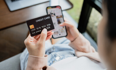 Woman hand holding credit card and smartphone for paying online using banking service. Online shopping concept