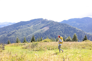 Canvas Print - Young woman with backpack hiking in mountains