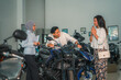 © Odua Images - Asian man with wife looking at some new motorcycles with sales at a motorcycle shop
