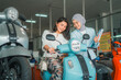 © Odua Images - young woman trying out a new motorcycle with a veiled saleswoman at a showroom
