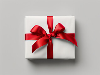 White gift box with silky red ribbon bow isolated on white background