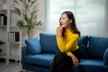 Wall Mural - young professional woman sitting on sofa pondering next steps in modern office