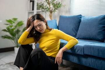 Wall Mural - young asian businesswoman suffering from headache at home