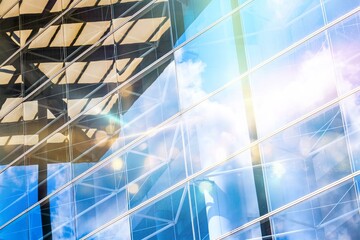 Wall Mural - A close-up of a modern building in Hong Kong, with a glass facade reflecting the sky and clouds.