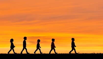 Wall Mural - Group of children walking on a quiet rural road, silhouetted against a glowing orange sunset sky