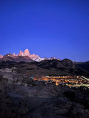 Fitz Roy rugged mountain ridge viewpoint at twilight dusk with El Chalten city birds eye view