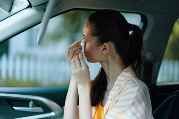 Wall Mural - woman applying makeup in car, personal grooming, beauty routine, self care, urban setting, casual attire, bright colors, soft natural light, modern lifestyle, reflective moment, serene atmosphere