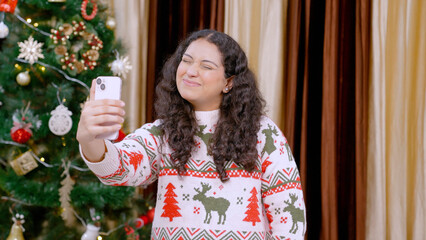 Indian Woman Clicking Funny Selfie with Christmas Tree in background