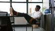 © Monkey Business - Young Businessman Relaxing Sitting In Office With Feet On His Desk In Office