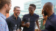 © Monkey Business - Multi-Cultural Business Team Meeting Outdoors For After Work Drinks On Office Rooftop Or Bar