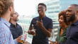 © Monkey Business - Multi-Cultural Business Team Meeting Outdoors For After Work Drinks On Office Rooftop Or Bar