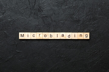 Microblading word written on wood block. Microblading text on cement table for your desing, concept