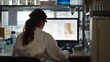 © VK Studio - A scientist in a lab coat examines a computer screen amidst an organized laboratory setting, suggesting focus and scientific discovery.