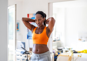 smiling woman in sports clothes at her home