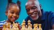 © Angelo - A grandfather showing his granddaughter how to play chess, both laughing, blue background.smiling, family, game, happiness, learning, fun, strategy