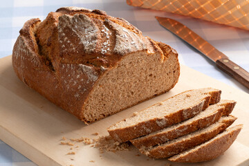  Fresh homemade loaf of sliced wheat and rye bread on a cutting board close up