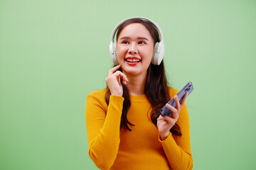 Young woman smiling with headphones and using smartphone.