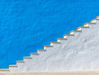 © niwat - A set of stairs ascending a large blue wall