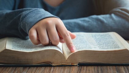 A teenage hand resting on the Bible's pages