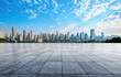 © oksa_studio - Empty marble floor overlooking modern city skyline with blue sky